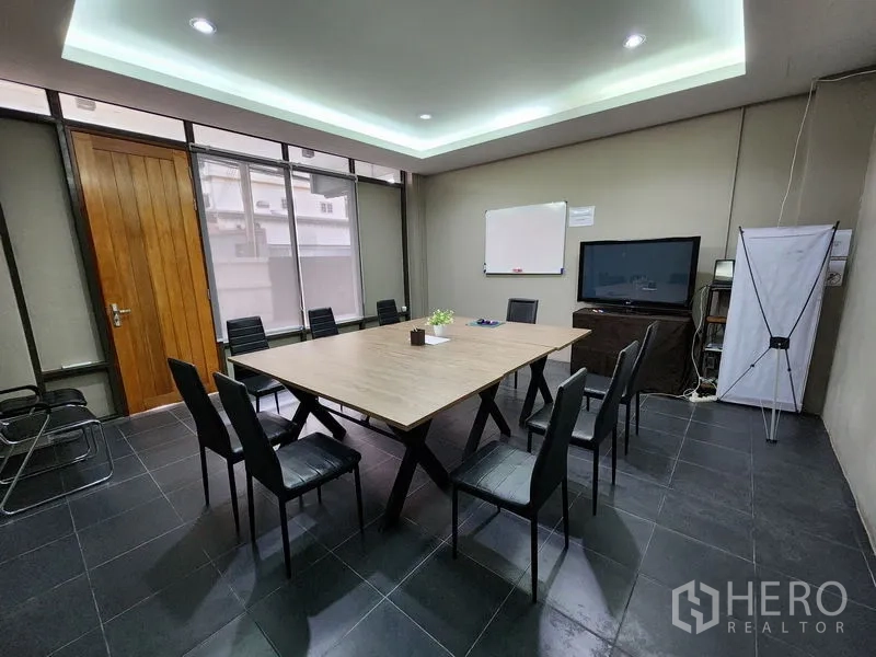 Home Office for rent in Mueang Nonthaburi, Nonthaburi - Boardroom with wood meeting table, LED cove lighting and floor-to-ceiling windows.