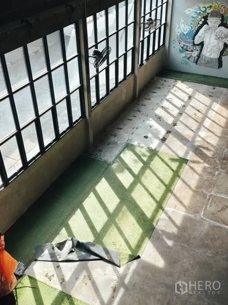 คลังสินค้า ให้เช่าในKhlong Toei, Bangkok - ภายในโกดังรับแสงธรรมชาติ หน้าต่างบานกริด พื้นคอนกรีต หญ้าเทียม และภาพกราฟฟิตีบนผนัง