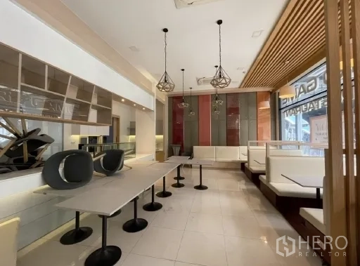 零售空间 出租在Khlong Toei, Bangkok - 现代咖啡馆风格室内，卡座、吊灯与长桌，亮面地砖。