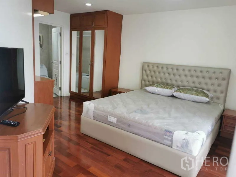 คอนโด ให้เช่า - ห้องนอนใหญ่เตียงหุ้มบุ ตู้เสื้อผ้าบานกระจก และห้องน้ำในตัว