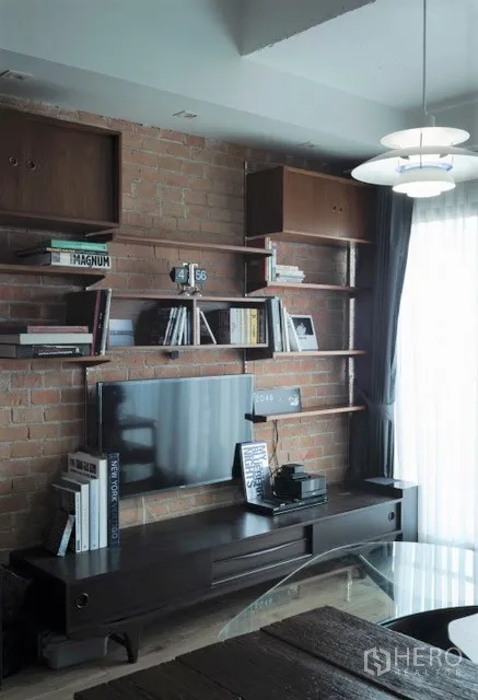 公寓 出租在Khlong Toei, Bangkok - 裸砖特色墙，电视柜与开放式书架陈列书籍。