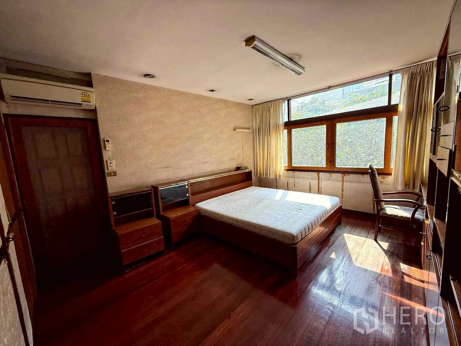 Home Office for rent in Bang Rak, Bangkok - Furnished room with bed, built-in cabinets, chair and wide windows.