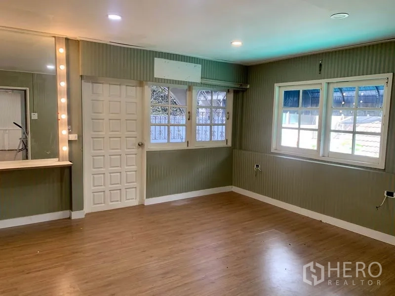 พื้นที่ขายปลีก ให้เช่าในKhlong Toei, Bangkok - ห้องสตูดิโอมุมห้อง พื้นลายไม้ โต๊ะเครื่องแป้งพร้อมไฟกระจก และหน้าต่างมีเหล็กดัด