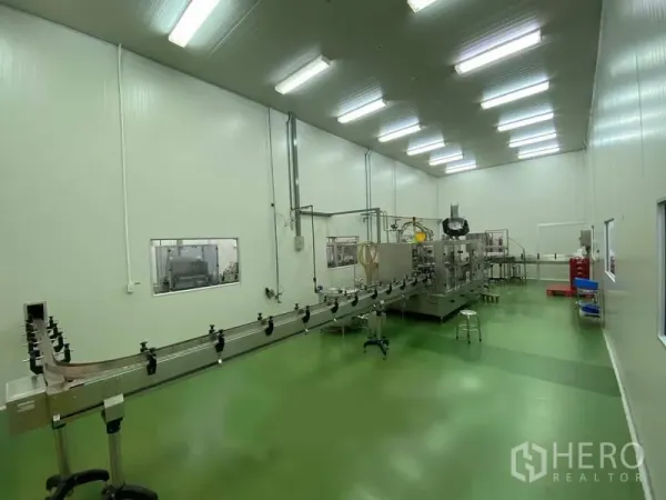 货栈 出租在Bueng Kum, Bangkok - 洁净室内绿色环氧地坪与瓶装生产线，照明明亮。