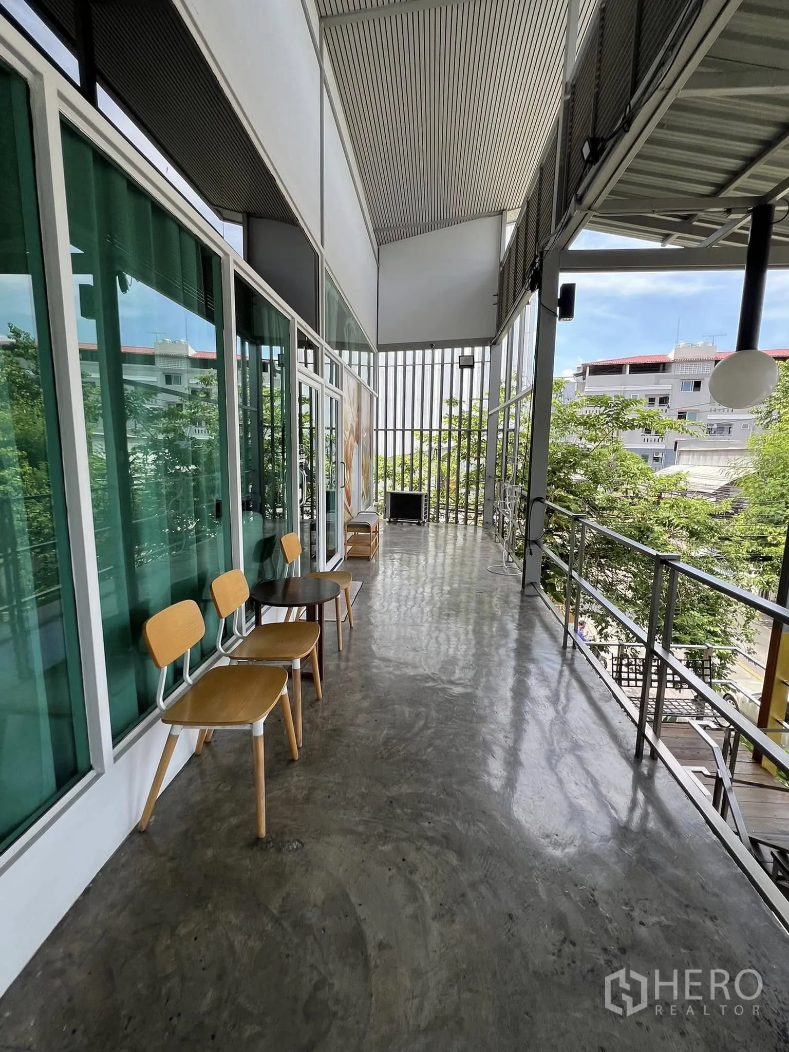 Retail Space for rent in Lat Phrao, Bangkok - Covered exterior balcony with chairs and tables overlooking greenery.