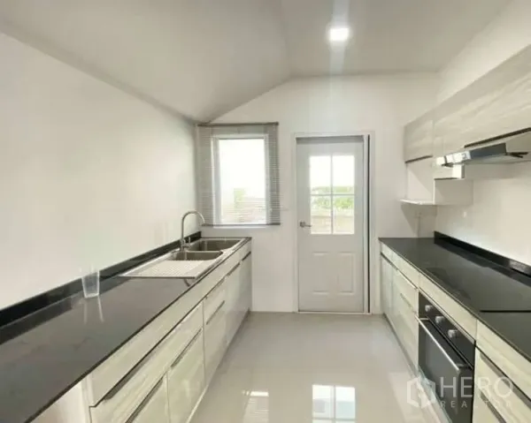 บ้าน ขายในBang Khen, Bangkok - ครัวบิวท์อินเคาน์เตอร์คู่ ซิงก์ เตา เครื่องดูดควัน และประตูออกลานซักล้าง