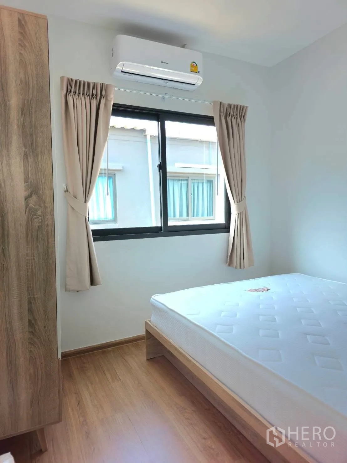 Townhouse for rent in Bang Phli, Samut Prakan - Secondary bedroom with bed, wardrobe, window, curtains and air conditioner.