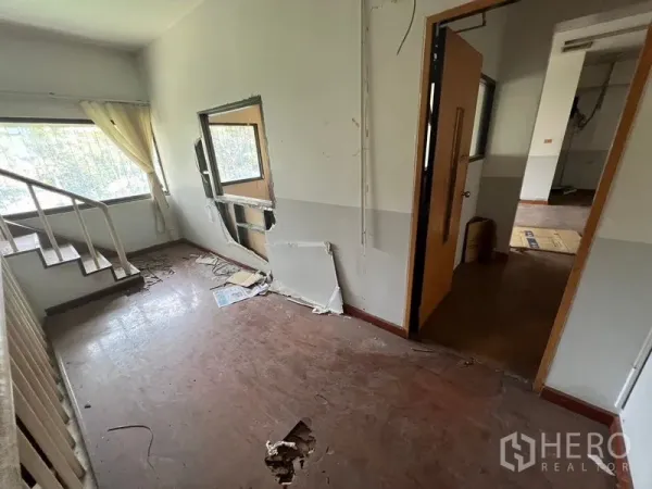 店屋 出租在Huai Khwang, Bangkok - 楼上一间带楼梯的房间，墙面破损，采光良好。