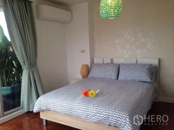 คอนโด ให้เช่าในKhlong Toei, Bangkok - ห้องนอนที่สองมีเครื่องปรับอากาศ ผ้าปูเตียงลายแพตเทิร์น และต้นไม้ริมประตูกระจก