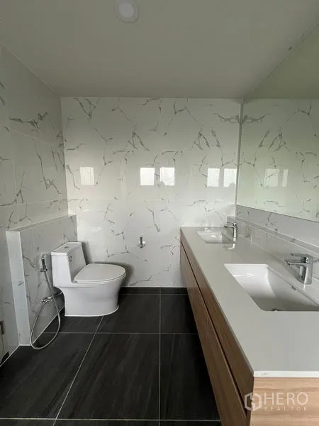 Detached House for rent or sale in Bang Phli, Samut Prakan - Bathroom featuring a double vanity, large mirror, toilet and dark floor tiles.