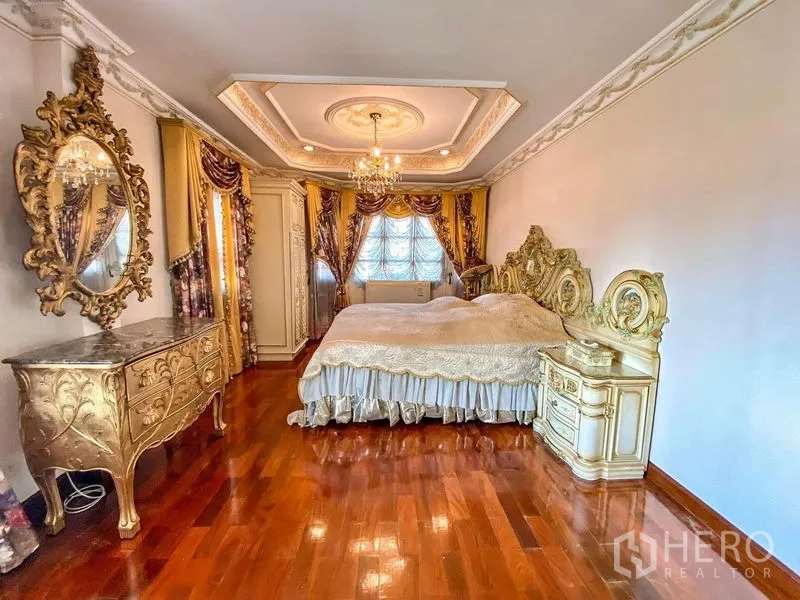独立式住宅 出租或出售在Bang Khen, Bangkok - 主卧配实木地板、雕花床、叠级天花与吊灯。