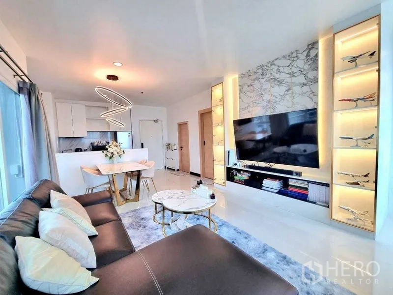 คอนโด ขาย - มุมจากโซฟาสู่ผนังทีวี ตู้โชว์ไฟ โต๊ะกลางซ้อนหินอ่อน และพื้นเงางาม