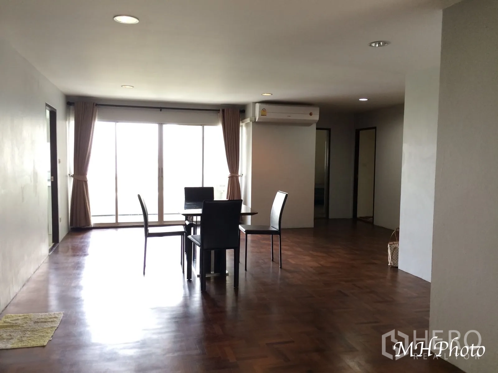 คอนโด ให้เช่าในWatthana, Bangkok - โซนรับแขกและรับประทานอาหารกว้าง พื้นปาร์เกต์ ไฟดาวน์ไลต์ และประตูกระจกบานเลื่อนออกสู่ระเบียง