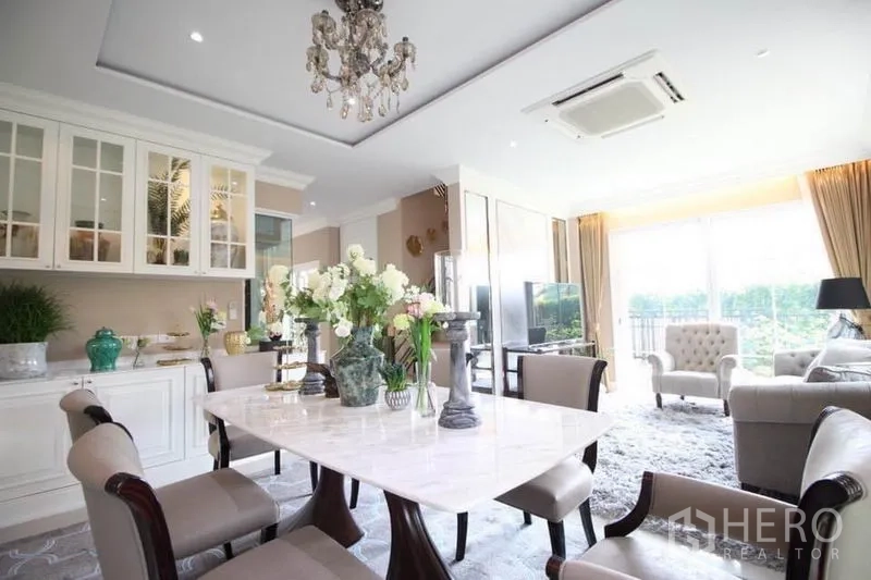 独立式住宅 出租或出售在Lat Phrao, Bangkok - 优雅餐厅，配大理石餐桌、玻璃橱柜与大窗户。