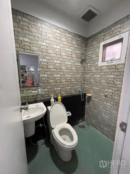 工厂 出租在Lat Lum Kaeo, Pathum Thani - 浴室，仿砖墙面，坐便器、洗手盆与淋浴区。