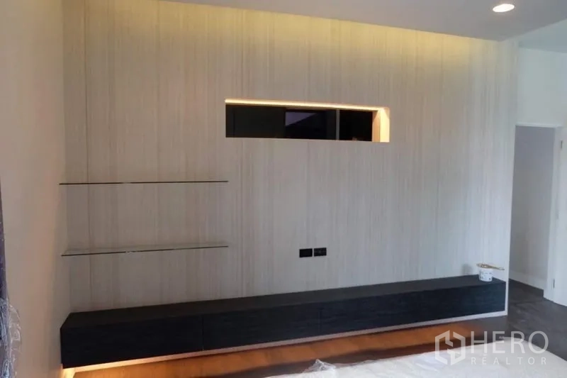 Detached House for rent in Bang Kapi, Bangkok - Bedroom media wall with floating cabinet, illuminated niche and glass display shelves.