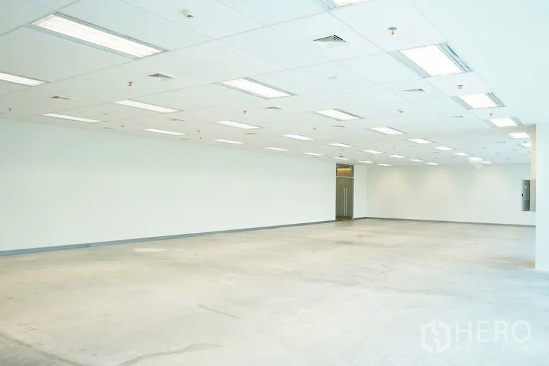 办公空间 出租在Bang Na, Bangkok - 开阔工作区，方格吊顶、近电梯厅，水泥地面。