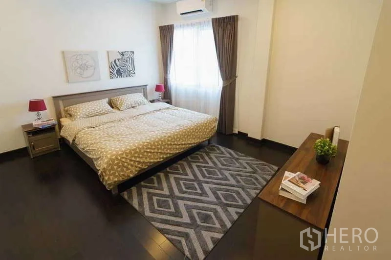 Detached House for rent or sale in Bang Phli, Samut Prakan - Comfortable bedroom with geometric rug, bedside lamps and air-conditioner.