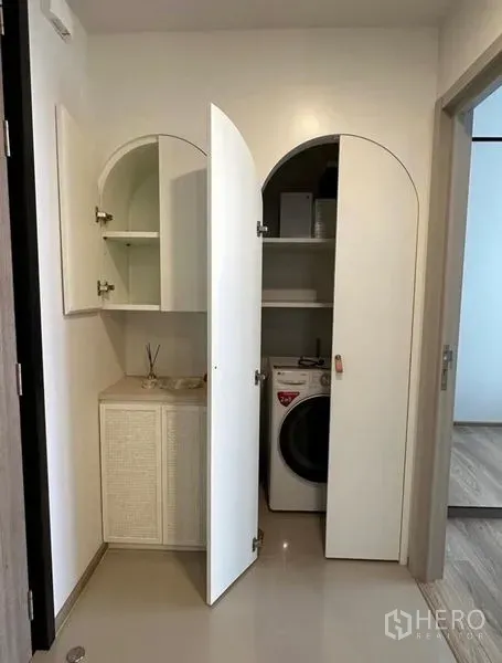 คอนโด ให้เช่า - ตู้เก็บของเปิดเผยให้เห็นชั้นวางและเครื่องซักผ้าฝาหน้า