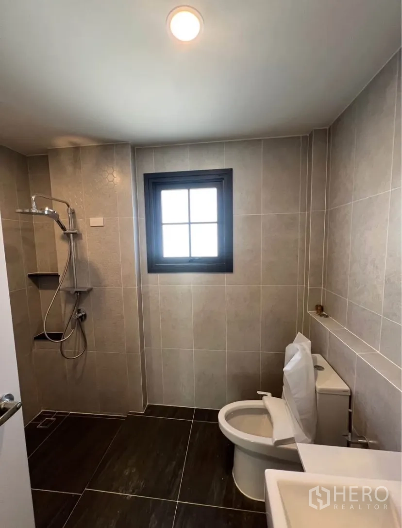 Detached House for rent in Bang Phli, Samut Prakan - Bathroom with walk-in shower, gray floor tiles and a window.