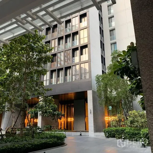 公寓 出租在Pathum Wan, Bangkok - 现代公寓入口，景观庭院与高挑外立面