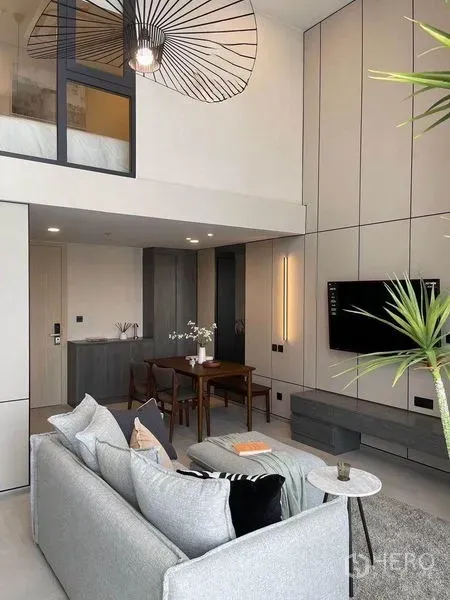 公寓 出租在Pathum Wan, Bangkok - 阁楼风格公寓，夹层卧室与玻璃隔断，个性吊灯、餐桌与高挑明亮客厅。