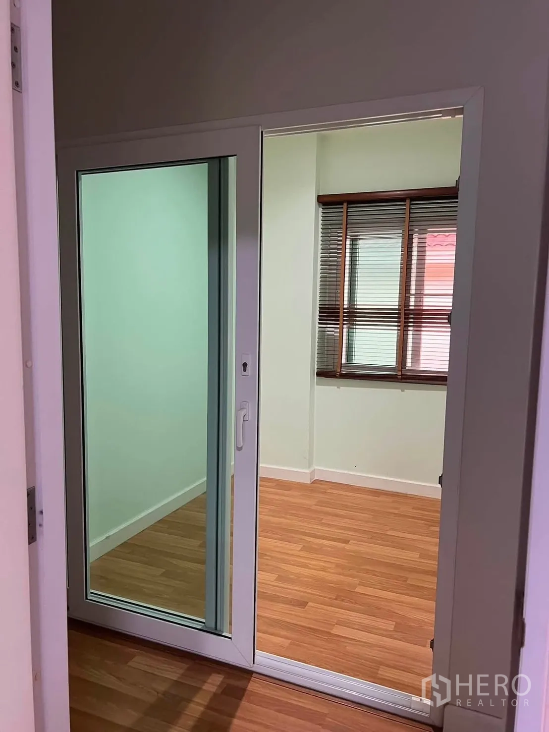 Detached House for rent in Watthana, Bangkok - Sliding glass door opening to a small room with wood flooring and window blinds.