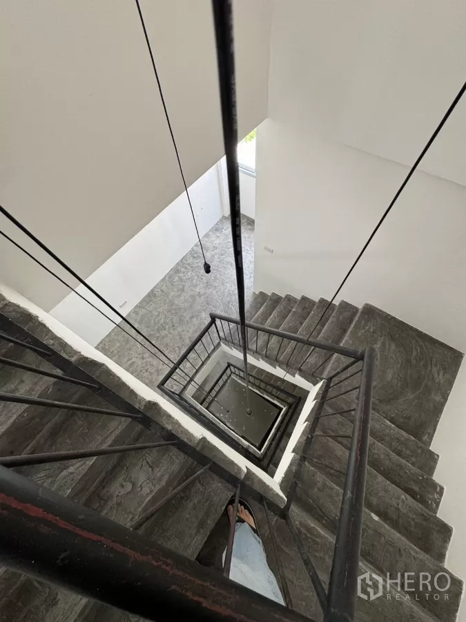 店屋 出租在Wang Thonglang, Bangkok - 中心楼梯井，金属扶手，自上而下视角。