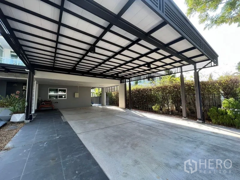 บ้าน ขาย - ที่จอดรถในร่มขนาดใหญ่ หลังคาเหล็ก พื้นที่จอดได้หลายคัน ขอบรั้วไม้พุ่ม
