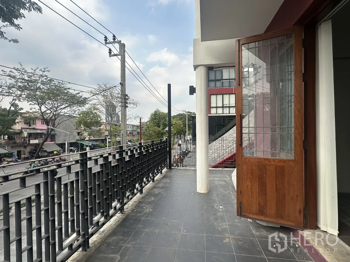 带办公室的家 for rent in Pathum Wan, Bangkok - 宽阔露台，格栅栏杆与木质双开门连接室内。