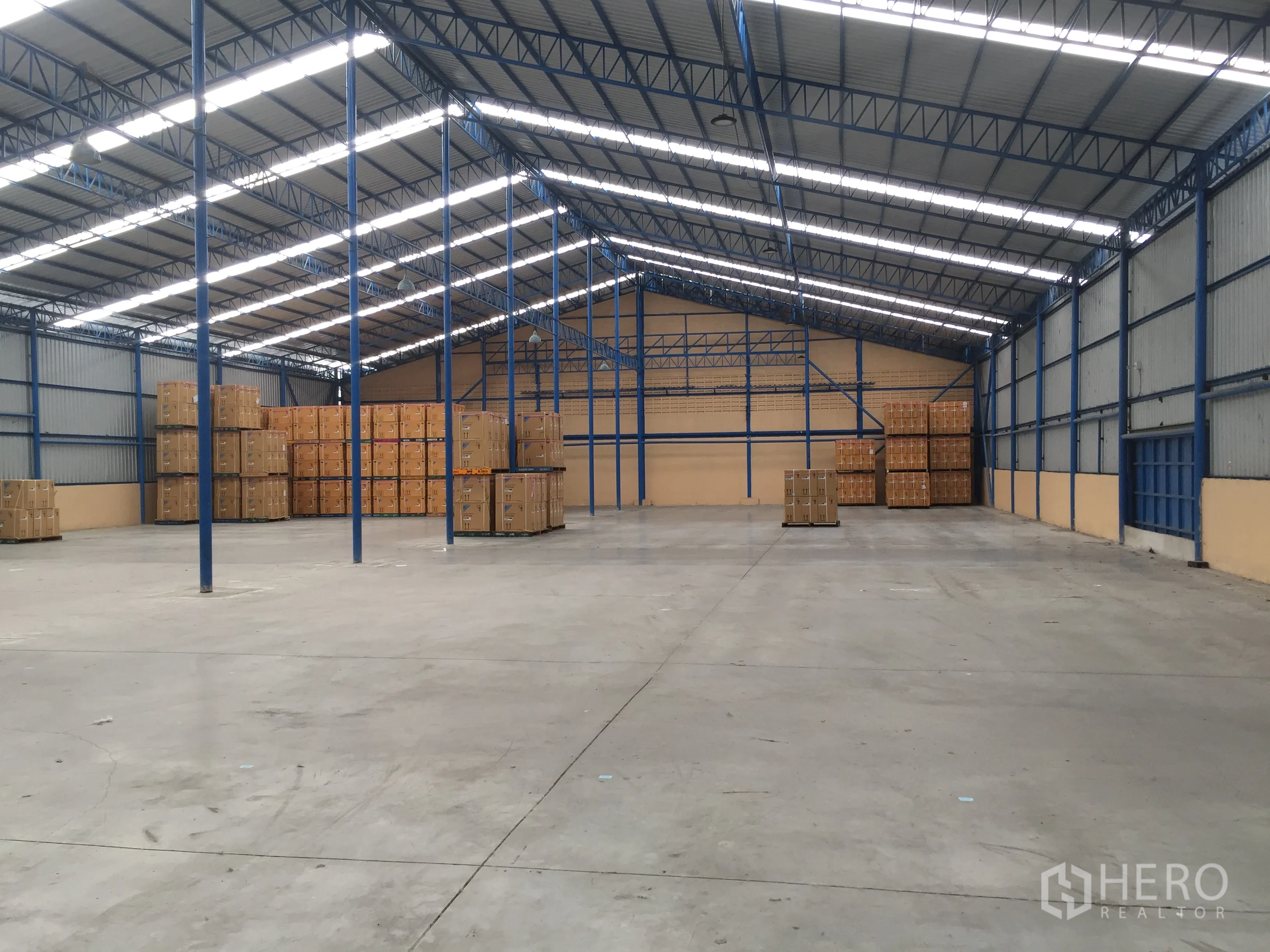 货栈 出租在Lat Krabang, Bangkok - 开阔仓储空间，堆放货物，高净空钢桁架屋顶、采光带与多处装卸口