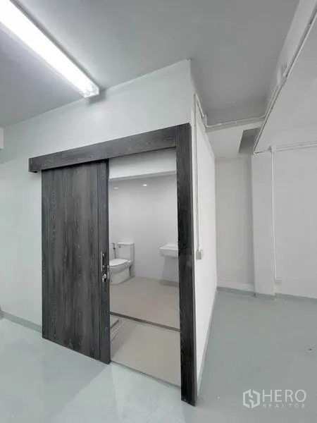 อาคารพาณิชย์ ให้เช่าในKhlong Toei, Bangkok - ประตูบานเลื่อนลายไม้ เปิดสู่ห้องน้ำสะอาดพร้อมโถสุขภัณฑ์และอ่างล้างหน้า