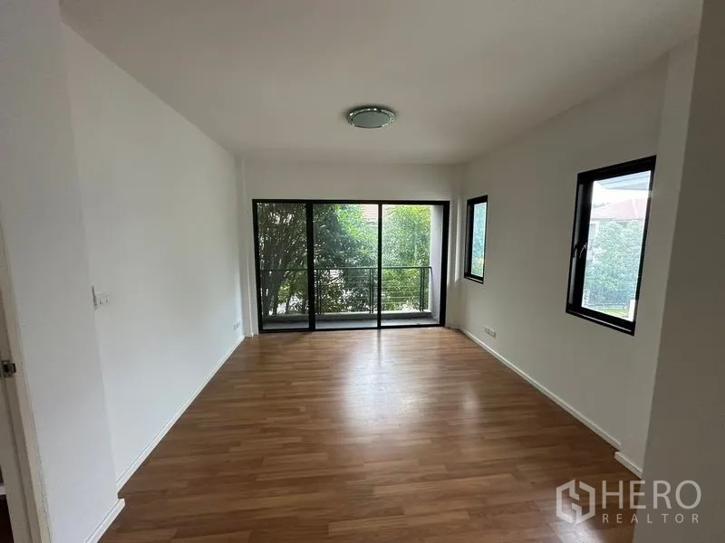 บ้าน ขายในBang Khen, Bangkok - ห้องชั้นบนพื้นไม้พร้อมหน้าต่างมุมและประตูบานเลื่อนออกระเบียง.