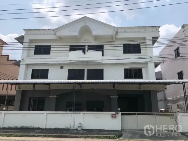 工厂 出租在Bang Bua Thong, Nonthaburi - 三层白色工厂建筑外立面，带大门与金属雨棚