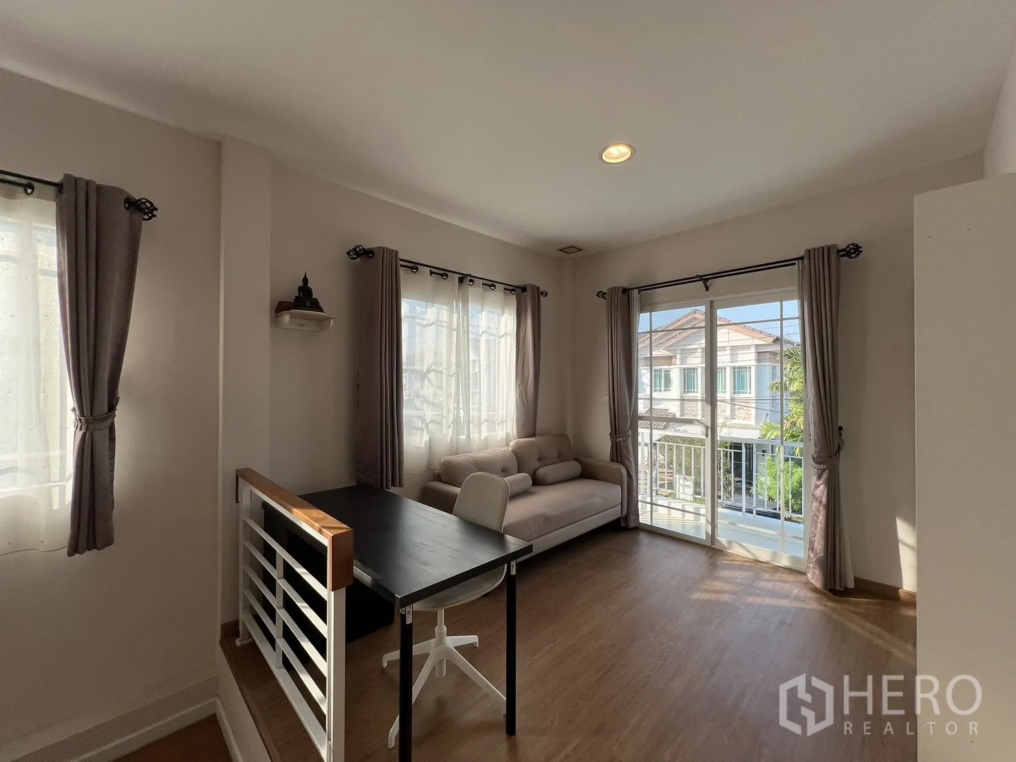 บ้านเดี่ยว for rent in Bang Kapi, Bangkok - พื้นที่ครอบครัวชั้นบนมีโซฟาและประตูกระจกเปิดสู่ระเบียง.