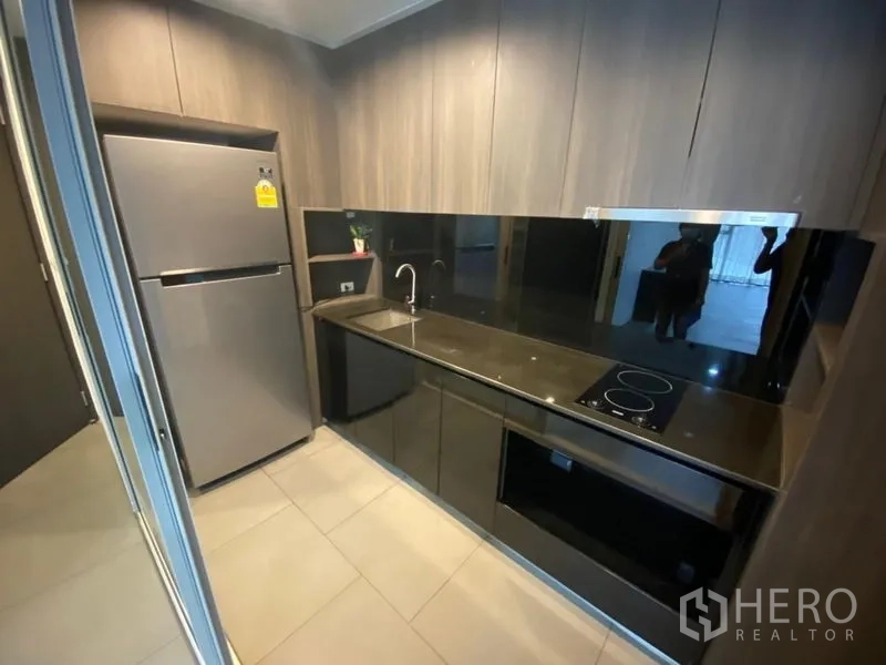 สำนักงาน ให้เช่าในPhaya Thai, Bangkok - แพนทรี่ขนาดกะทัดรัด เคาน์เตอร์สีดำ เตาไฟฟ้า และตู้เย็นสเตนเลส