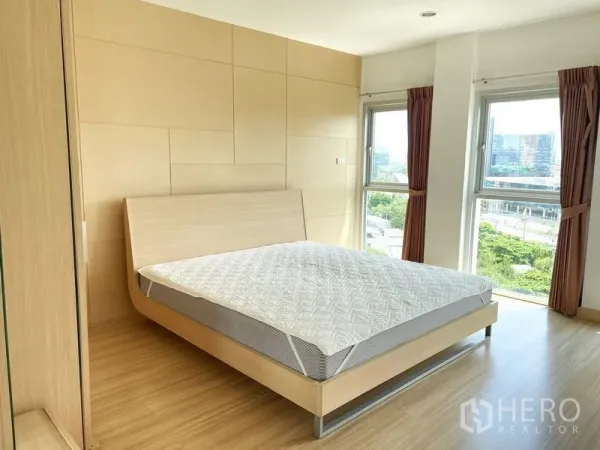 คอนโด ให้เช่าในKhlong Toei, Bangkok - ห้องนอนสว่างผนังลายไม้ เตียง และหน้าต่างมุมมองเห็นวิวเมือง