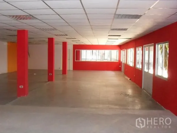 零售空间 出租在Khlong Toei, Bangkok - 宽敞的开放式室内空间，红色立柱与墙面、地砖、吊顶和大窗户。