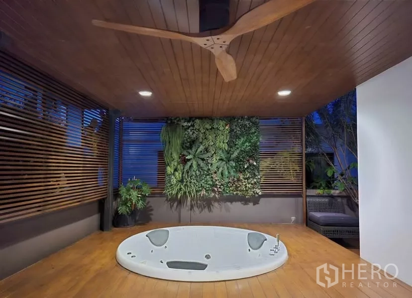 独立式住宅 出租在Bang Phli, Samut Prakan - 室外按摩浴缸置于木平台，配垂直绿植墙