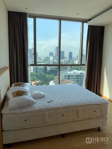 Condominium for rent in Watthana, Bangkok - Bedroom with large window, queen bed and sweeping city view.