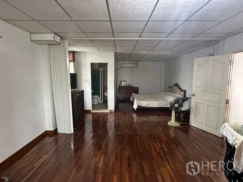 Home Office for sale in Phra Pradaeng, Samut Prakan - Spacious bedroom with polished wood flooring and an attached bathroom.