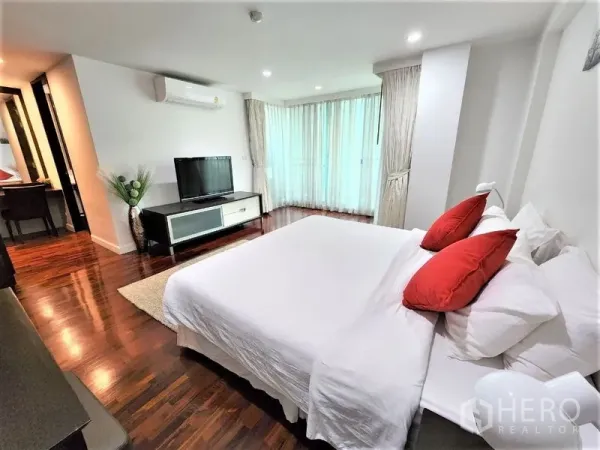 公寓 出租在Bang Rak, Bangkok - 主卧角度，带电视柜、落地窗、分体空调和木地板。