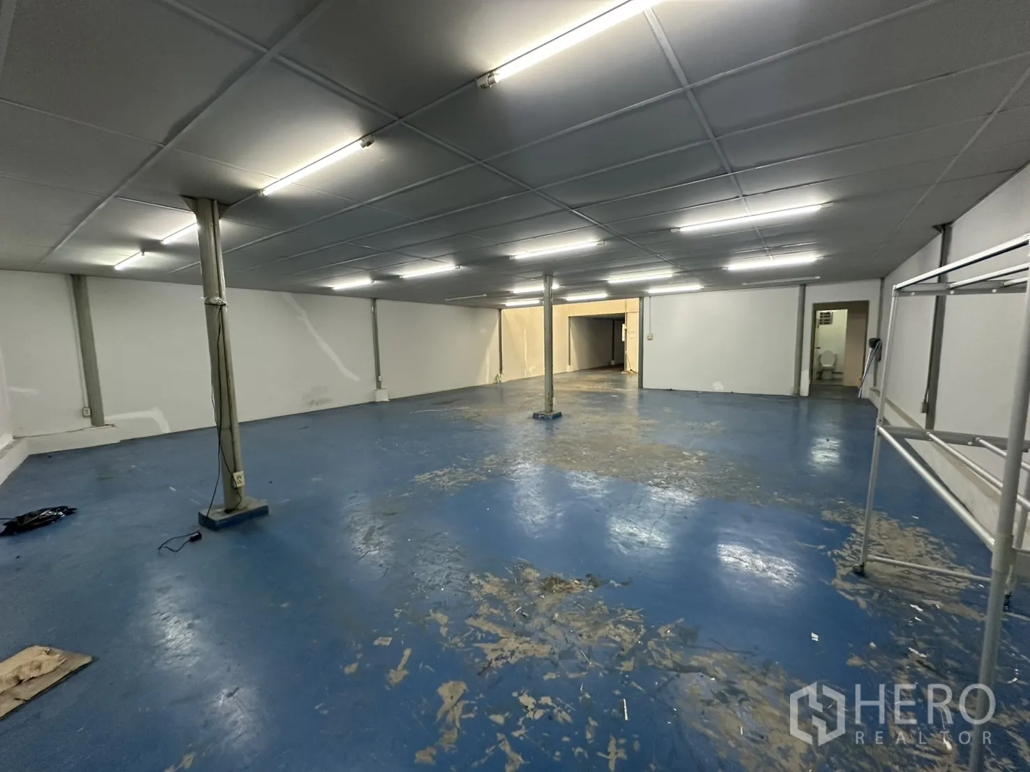 Warehouse for rent in Suan Luang, Bangkok - Warehouse interior from opposite side showing support columns and storage area.