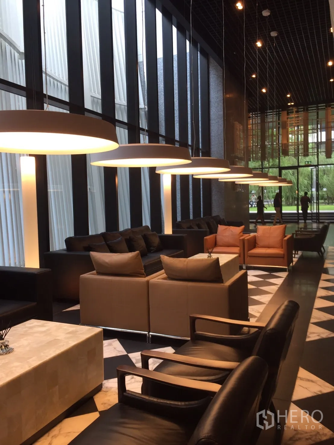 Condominium for sale in Pathum Wan, Bangkok - Stylish lobby lounge with sofa seating, pendant lights, and full-height windows.