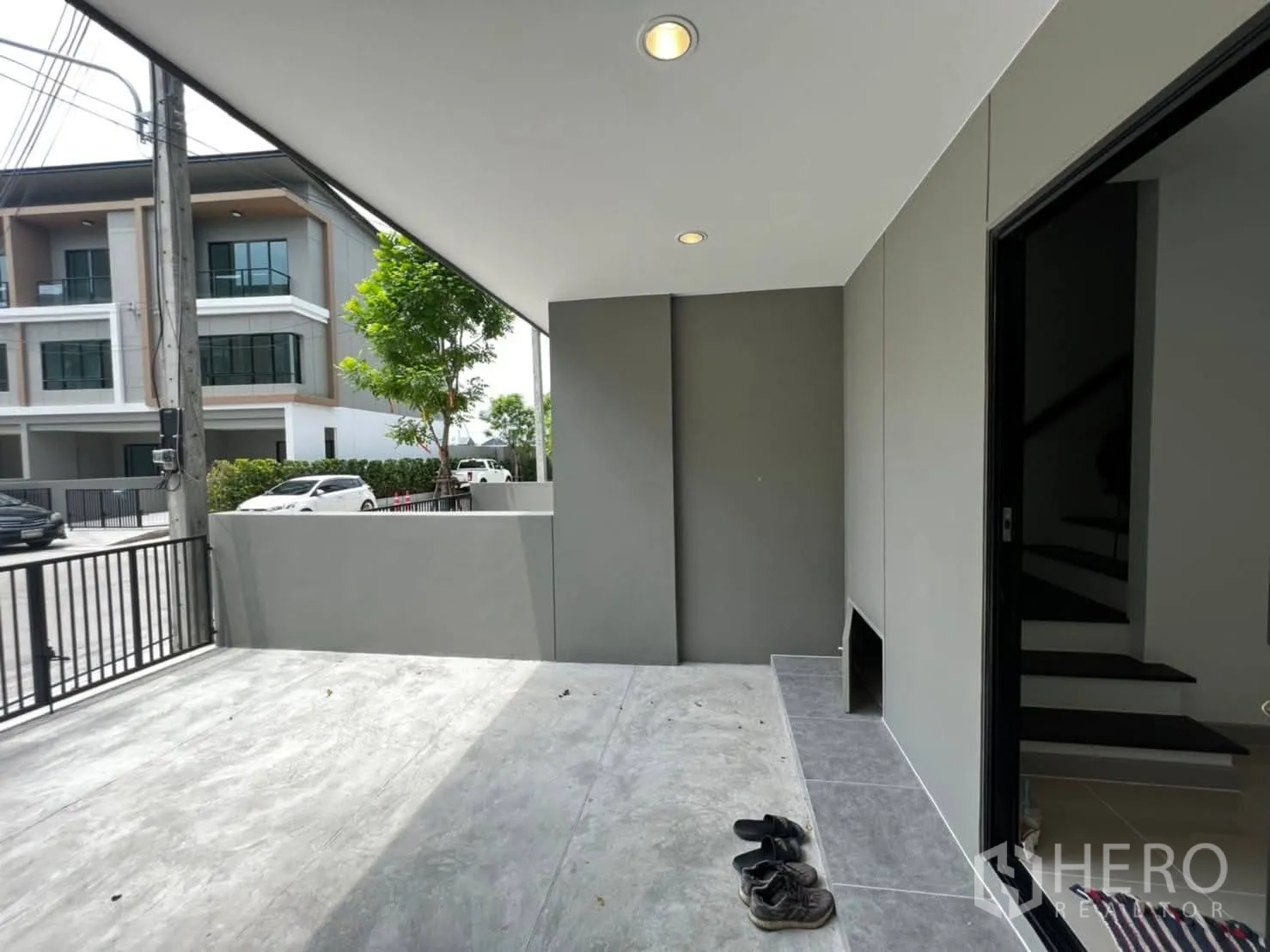 Townhouse for rent in Bang Khen, Bangkok - Covered front terrace or parking area with ceiling lights and gated street view.