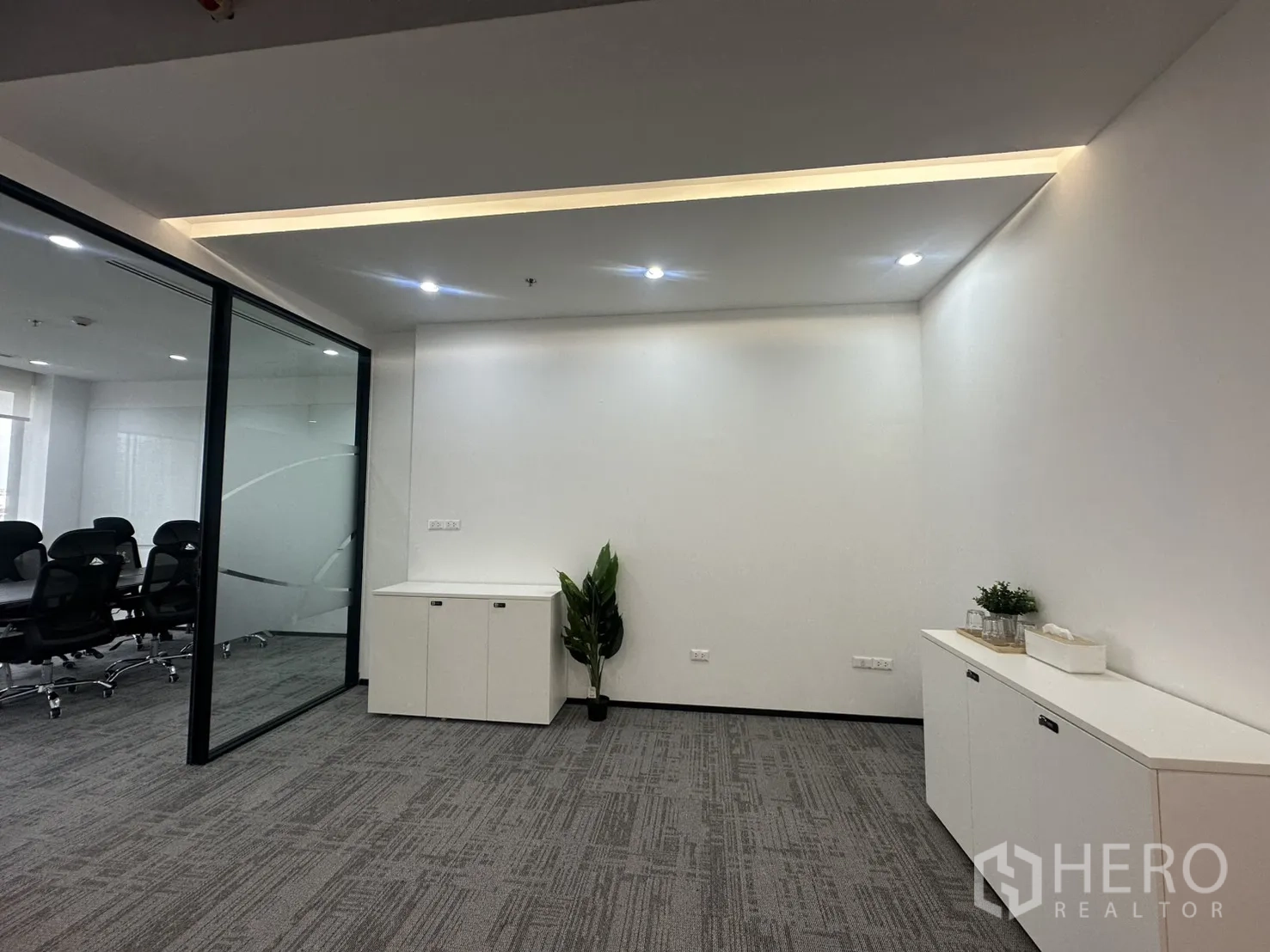 办公室 for rent in Pathum Wan, Bangkok - 走廊区域设收纳柜与绿植，玻璃隔断通往会议室。