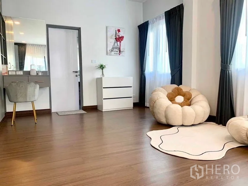 Detached House for rent or sale in Bang Phli, Samut Prakan - Spacious multipurpose room with vanity desk, plush lounge chair and large windows.