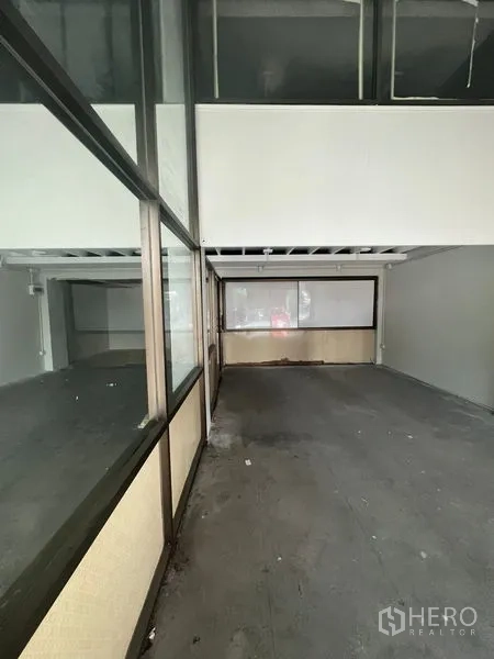 店屋 出租在Khlong Toei, Bangkok - 沿金属框玻璃墙的长形商业空间，位于夹层下方。