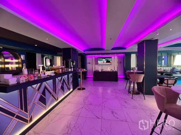 พื้นที่ขายปลีก ให้เช่า - มุมมองกว้างของเคาน์เตอร์บาร์สไตล์อาร์ตเดโค ไฟใต้เคาน์เตอร์ พร้อมไลน์บุฟเฟต์ ในพื้นที่ค้าปลีกไฟ LED สีม่วง