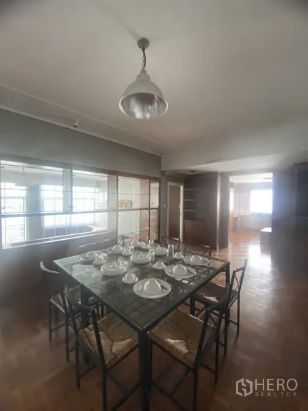 公寓 出租在Sathon, Bangkok - 餐区设玻璃餐桌八人位，吊灯与玻璃隔断墙。